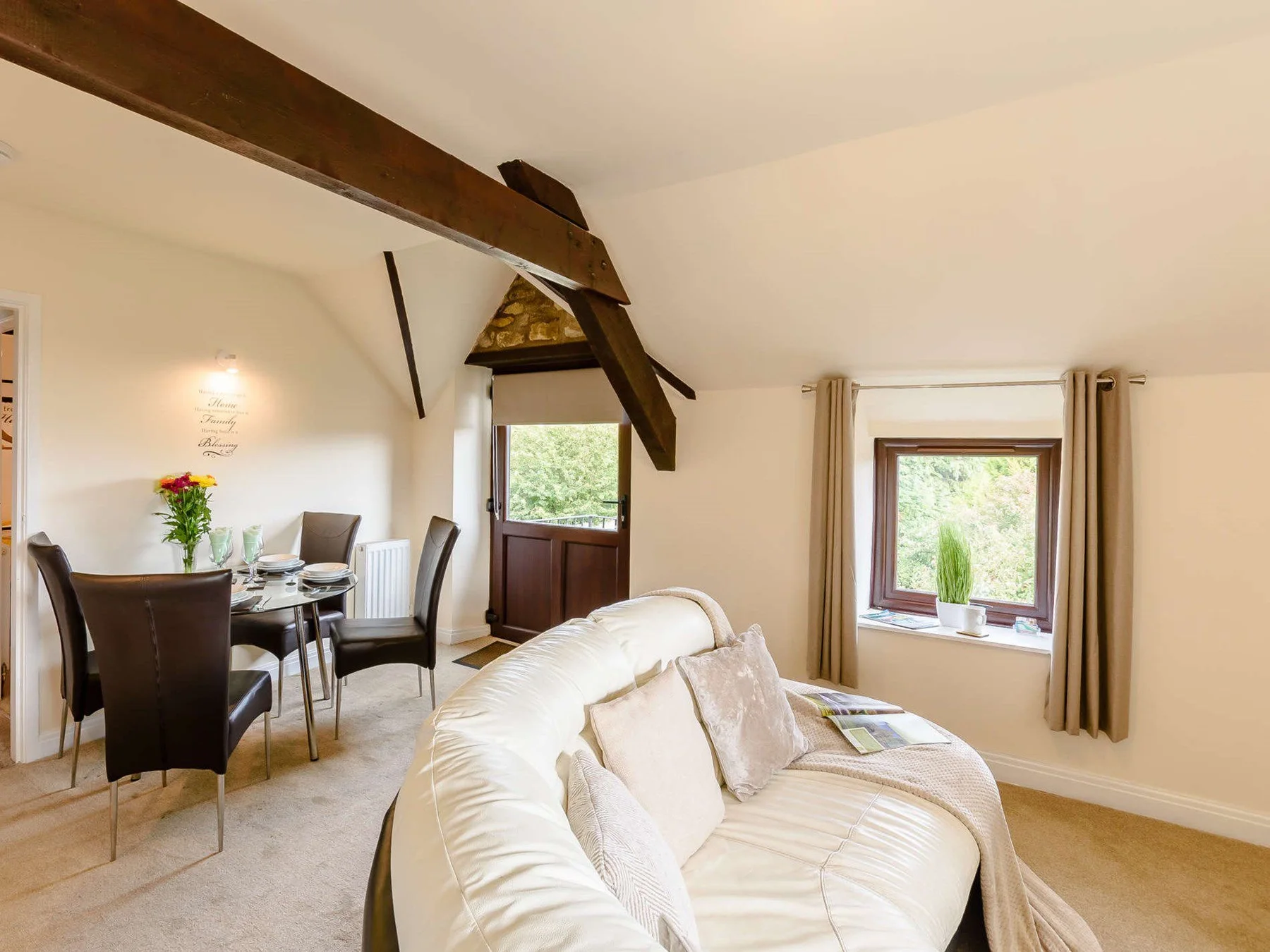 Relaxed lounge and dining area beneath exposed beams